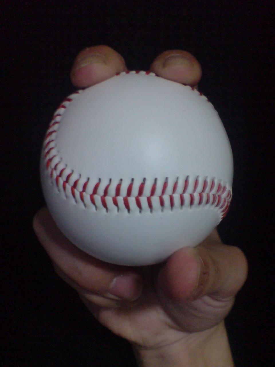 Front view · ball and fingers of Four-seam fastball; Four-seam example: the broad transverse seam and two supporting fingertips are visible.
