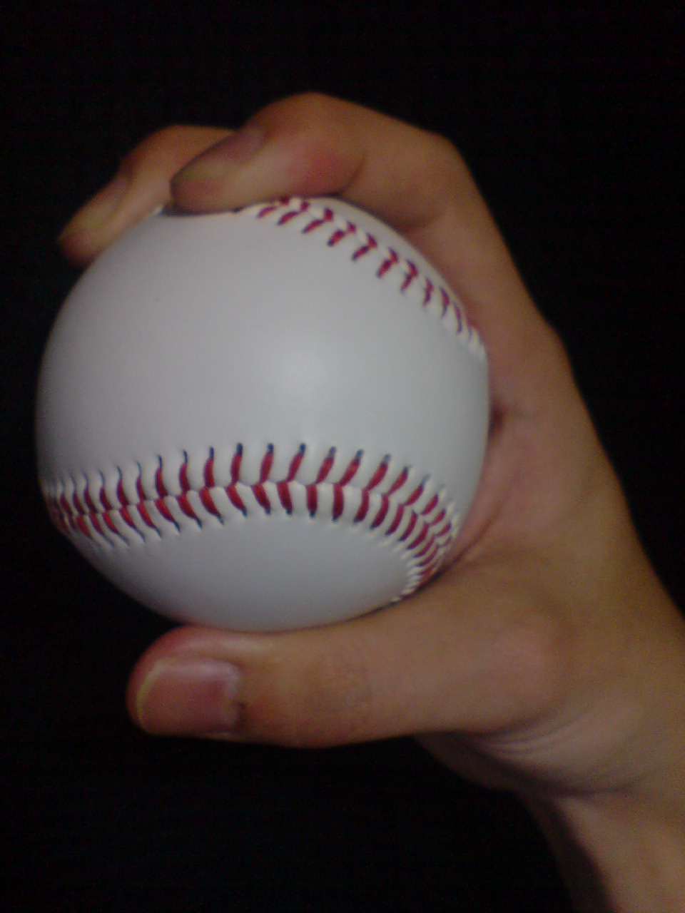 Side view · thumb and depth of Four-seam fastball; Four-seam example: the broad transverse seam and two supporting fingertips are visible.