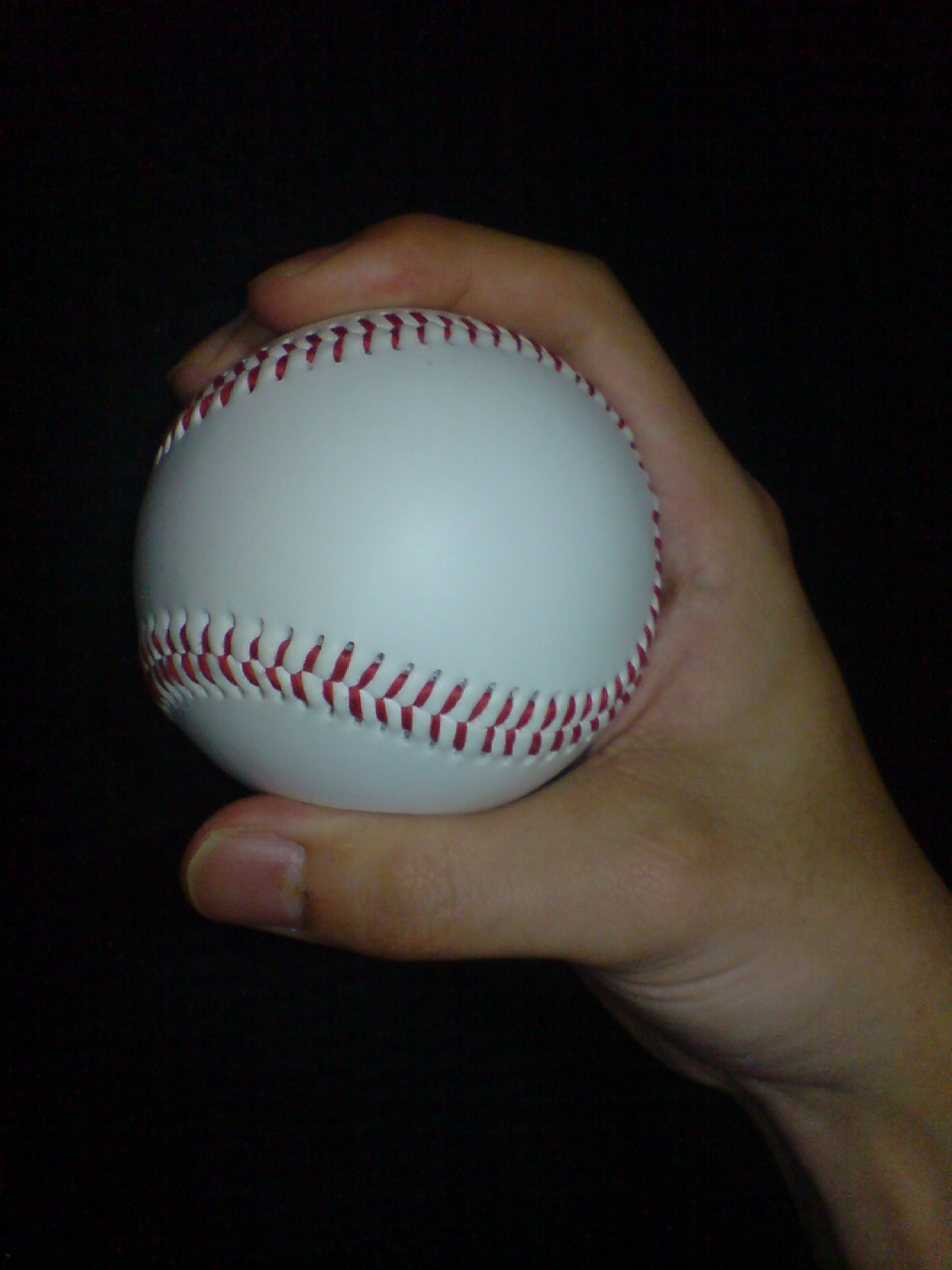 Side view · thumb and depth of Two-seam fastball; Two-seam example: the ball orientation differs from the four-seam hold. Finger pads partly hide seam contact; ask your coach to show the paired seams under the fingers.